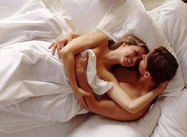 ženska v postelji z moškim, ki poveča svoj kurac
